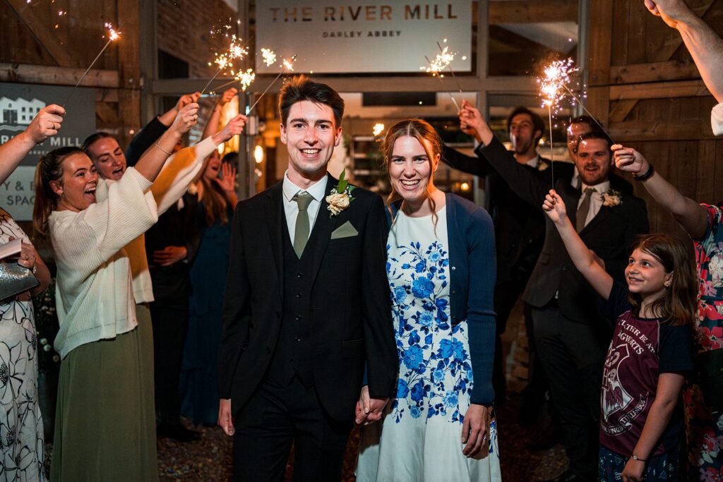 Couple celebrates with sparklers at wedding reception.
