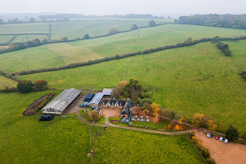 Aerial view of a countryside farm and fields.