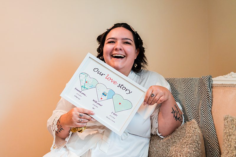 Smiling person holding framed love story map
