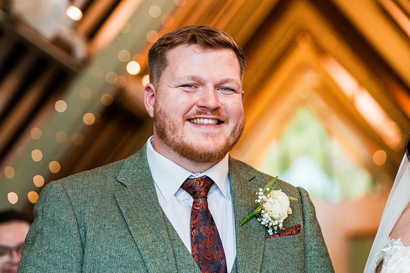 Smiling man in wedding attire indoors.