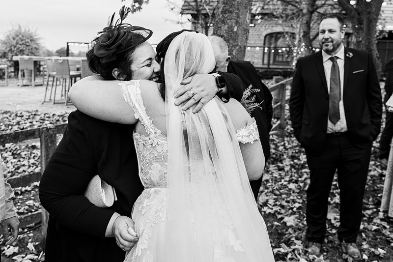 Bride hugging guest at autumn wedding