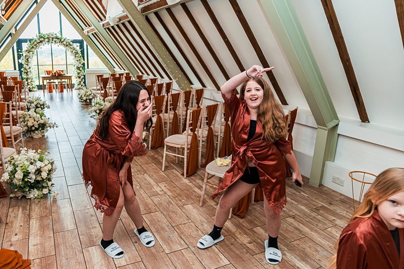 Bridesmaids in robes having fun before wedding ceremony.