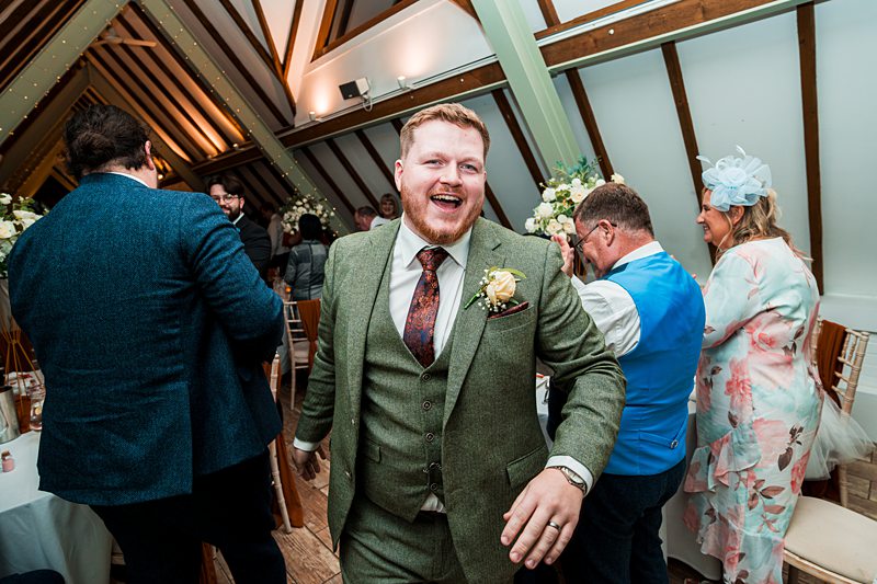 Smiling man in green suit at joyful gathering