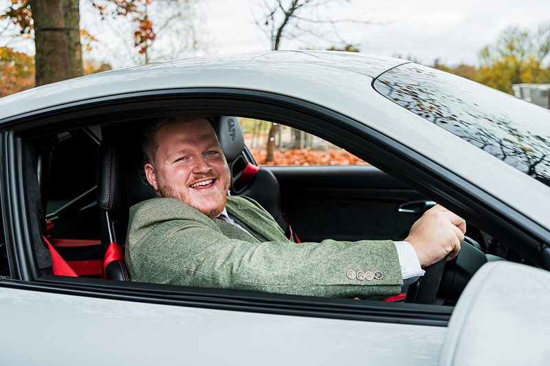Man smiling in a parked car