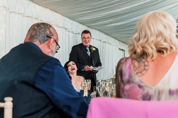 Man gives speech at wedding reception.