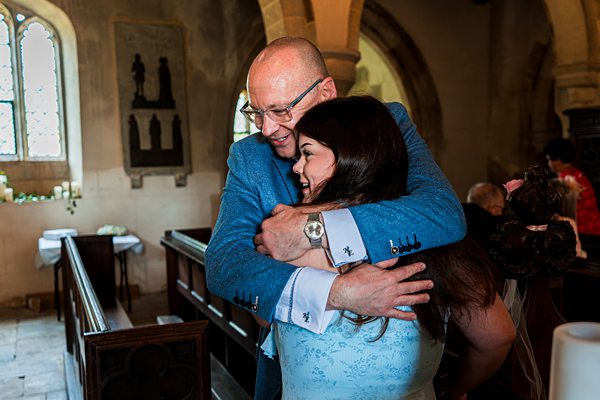 Man and woman hugging at a church service.