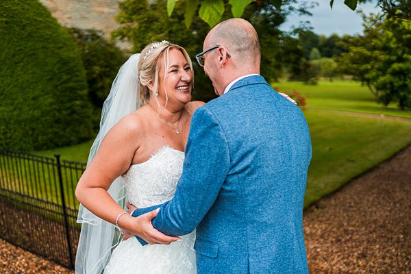 Happy bride and groom laughing outdoors.