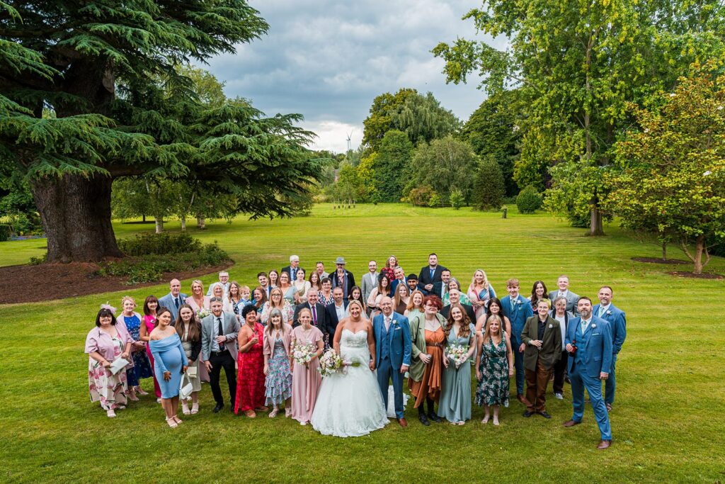 Wedding group photo in a garden setting.