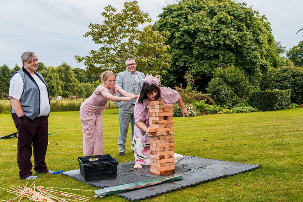 People playing giant Jenga on lawn.