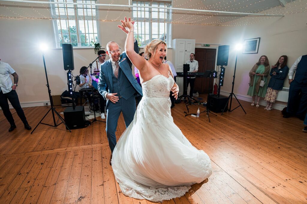 Couple joyfully dancing at wedding reception.