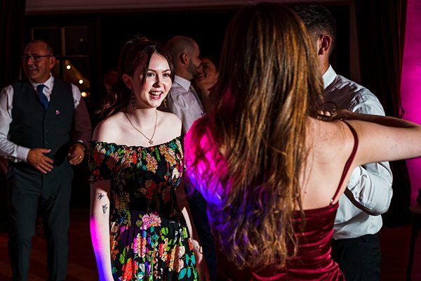 People dancing at a festive gathering, colourful dresses.