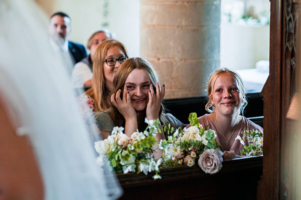 Guests smiling at wedding ceremony with flowers