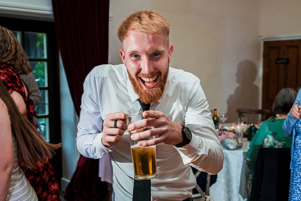 Man smiling with pint at a party