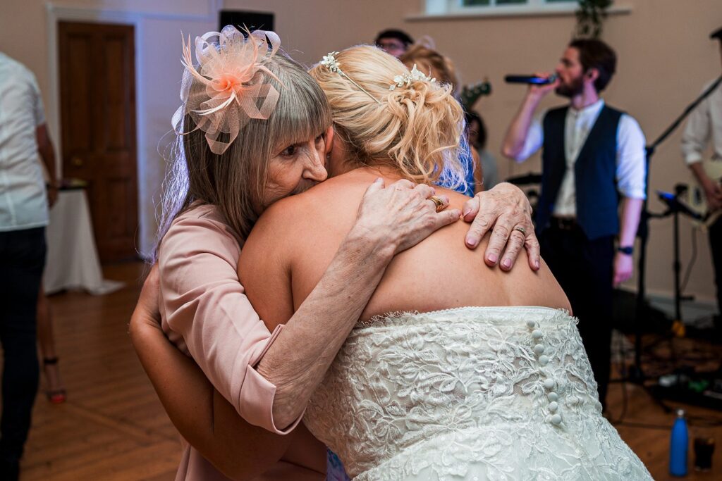 Elderly woman hugs bride at wedding reception
