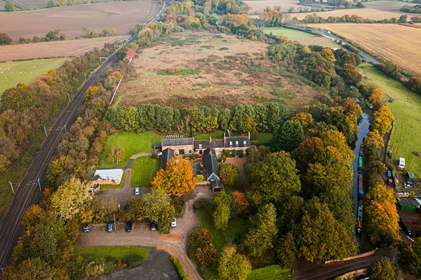 Aerial view of countryside with farm and railway.