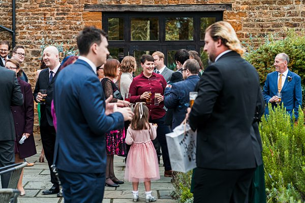 People gathered at an outdoor event, socialising and drinking.