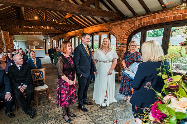Wedding ceremony in rustic barn venue with guests.
