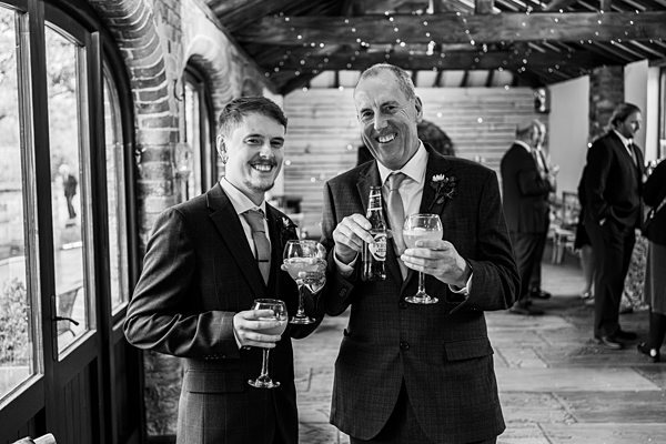 Two men in suits enjoying drinks together.