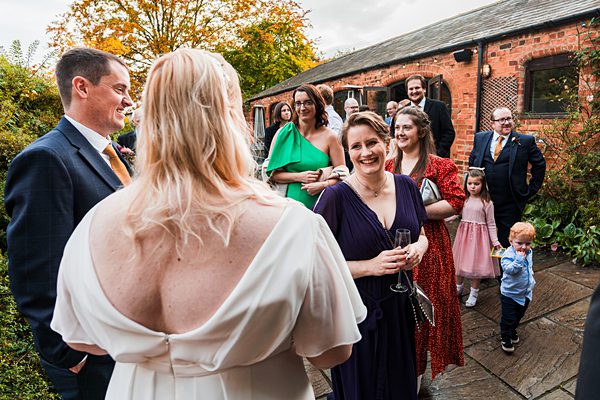 Guests socialising at outdoor wedding reception.
