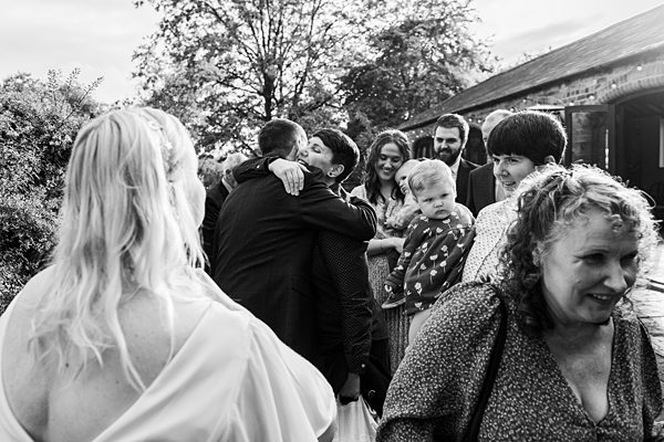 Guests hugging at outdoor wedding reception