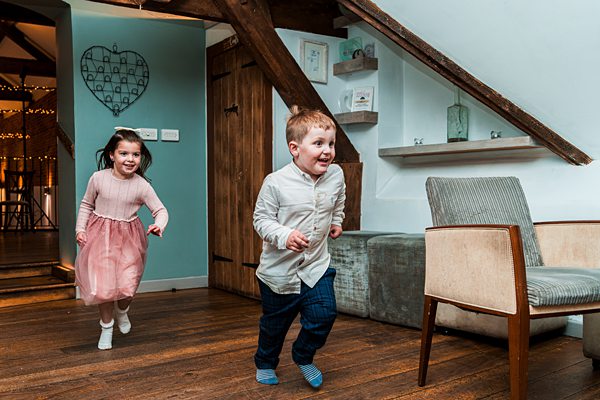 Children joyfully running indoors in a cosy room.