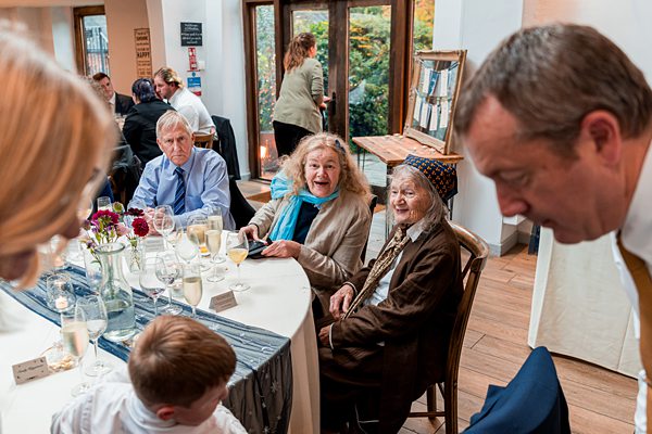 People talking at a round dining table gathering.