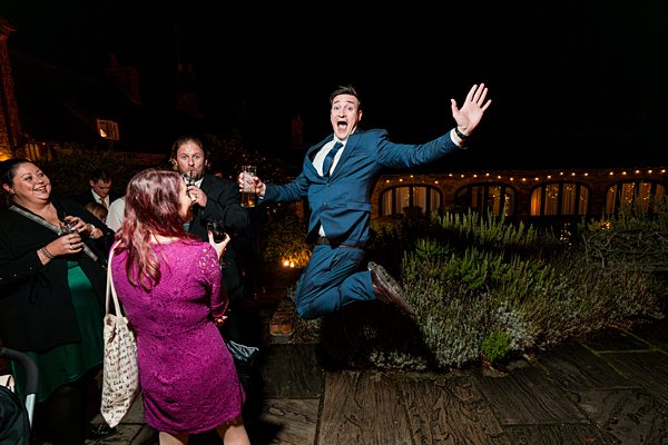 Man in suit jumps joyfully at night celebration.
