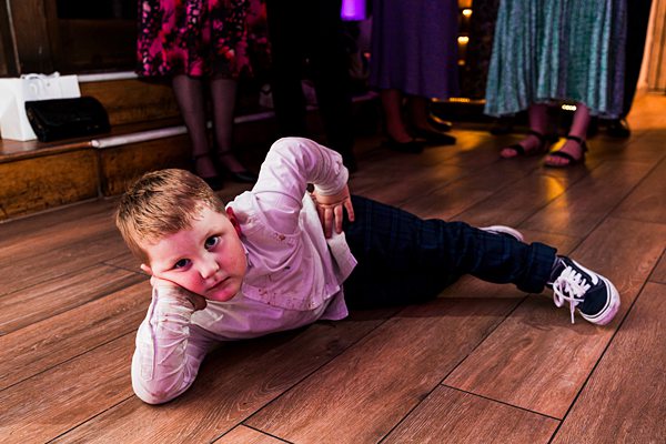 Child posing on dance floor at party.