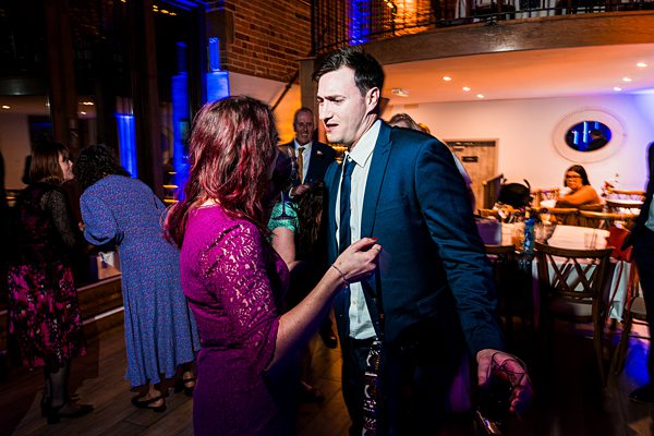 Guests dancing at a lively evening wedding reception.