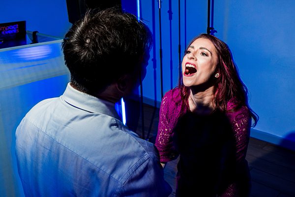 Woman singing passionately in blue-lit room