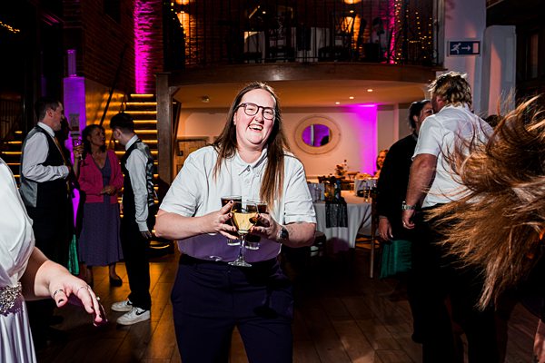 Person joyfully dancing at a lively party scene.