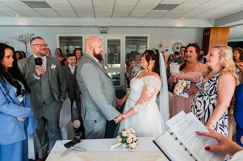 Bride and groom holding hands at wedding ceremony.