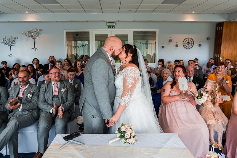 Bride and groom kiss at wedding ceremony.
