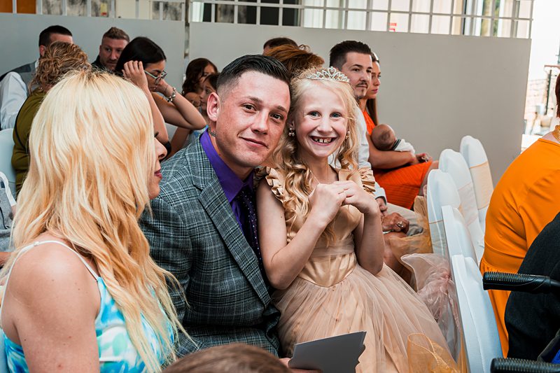 Smiling guests at a wedding ceremony.