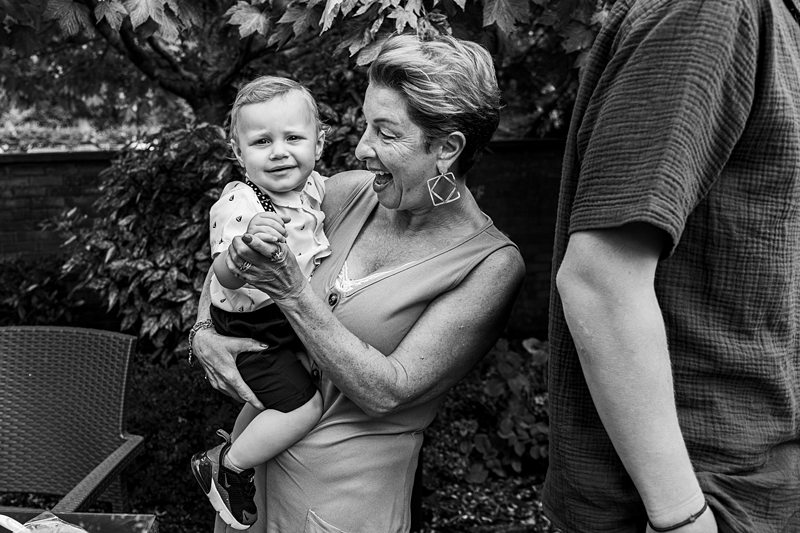 Woman joyfully holding baby outdoors.