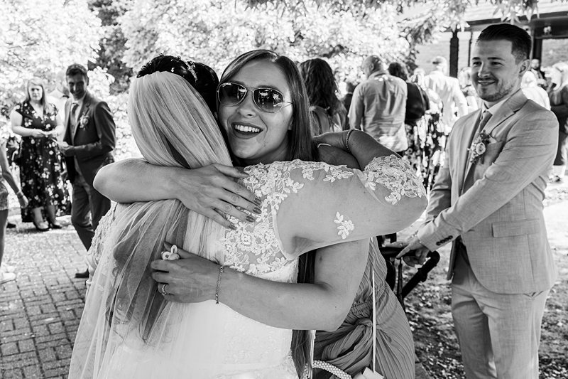 Wedding guests embracing outdoors in celebration