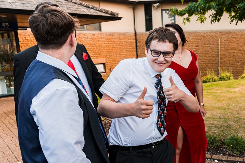 People smiling and socialising outside a building.