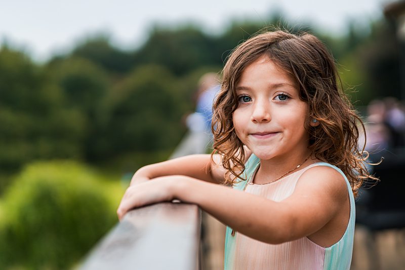 Young girl smiling outdoors on a sunny day.