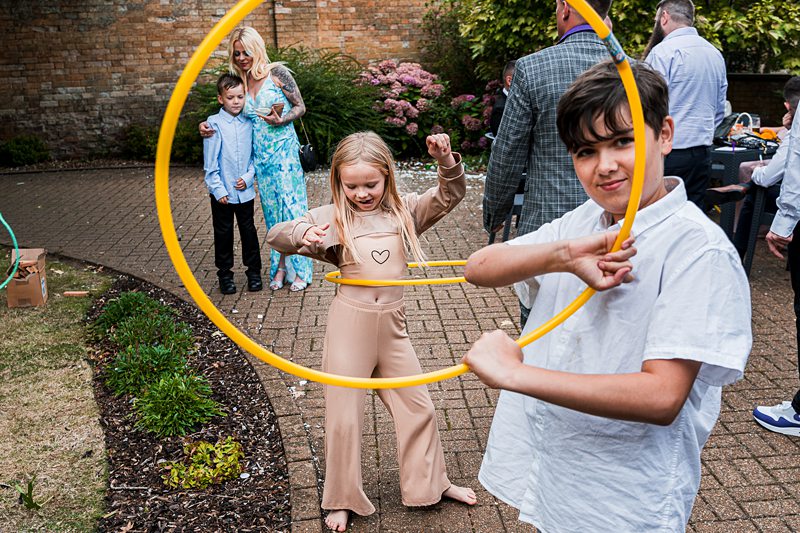Kids playing with hula hoops at outdoor party.