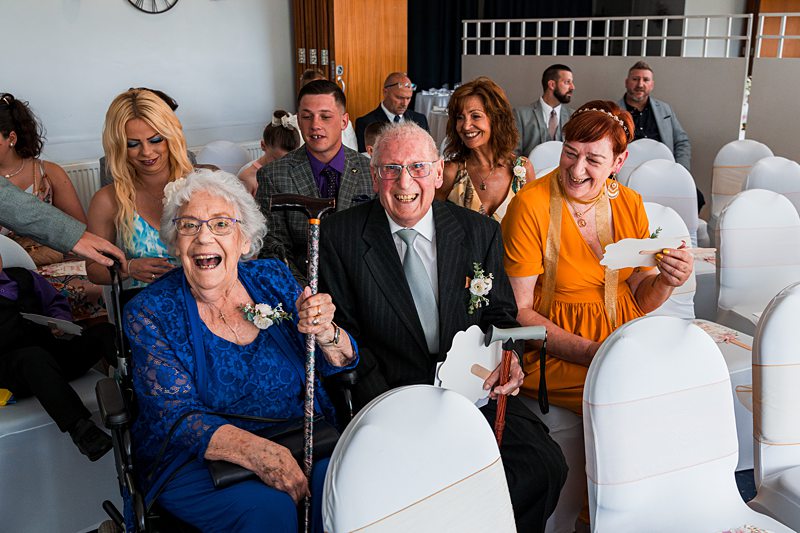Guests smiling at a wedding ceremony.