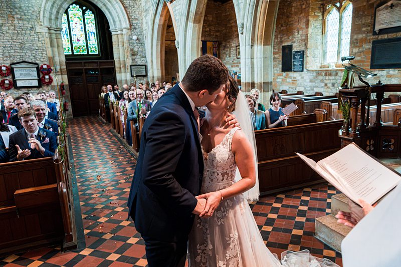 Wedding couple kissing in a church ceremony.