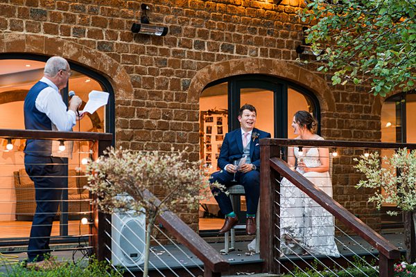 Wedding speech outdoors at rustic venue.