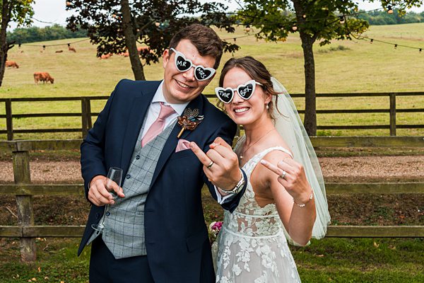 Happy couple at outdoor wedding in heart sunglasses.