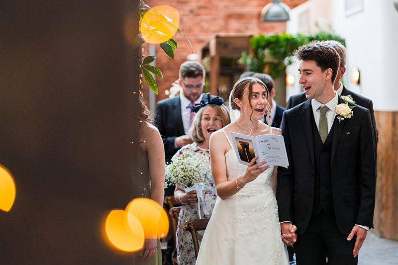 Wedding couple holding orders of service.