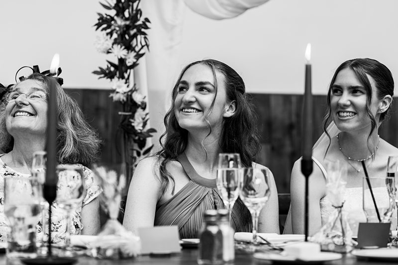 Three women smiling at a wedding reception.