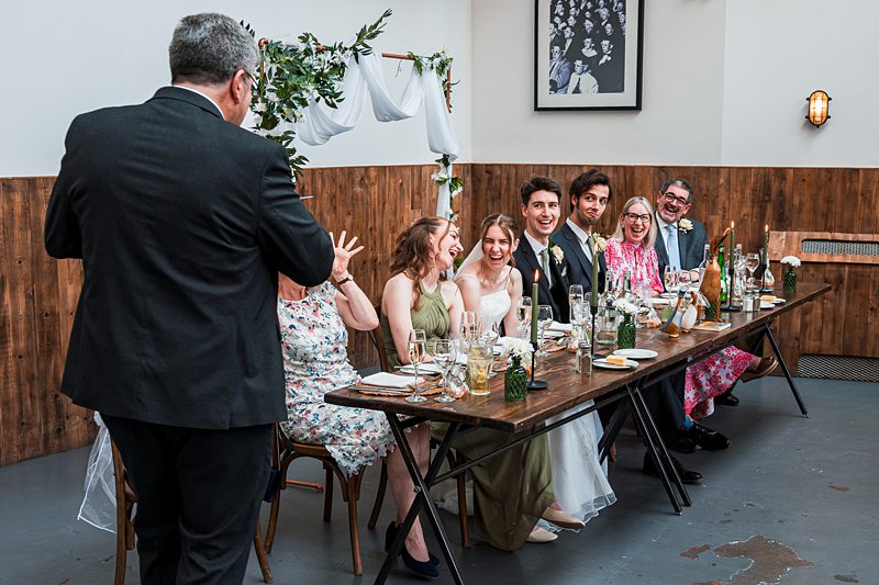 Wedding party laughing at dinner table