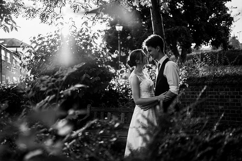 Wedding couple embracing in a garden, black and white.