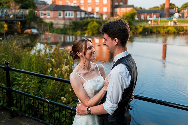 Couple embracing by a riverside backdrop