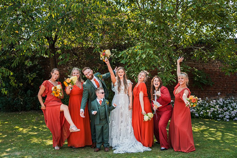 Wedding party posing with bouquets outdoors.