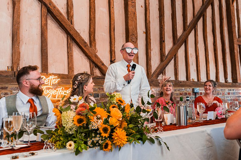 Wedding speech at decorated reception table.